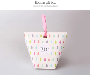 Detailed view of pink ribbon handle and eco-friendly coated paper gift box with sticker