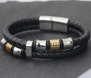 Detail of double-layer woven black leather bracelet with gold and silver magnetic clasp
