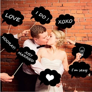 Wedding photo booth props with heart-shaped signs and 'Just Married' text in front of brick wall