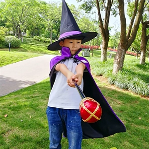 Close-up of kids wizard set including purple cape, black pointed hat and magic wand