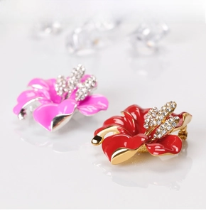 Detailed close-up of rose brooches with enamel petals and sparkling rhinestones