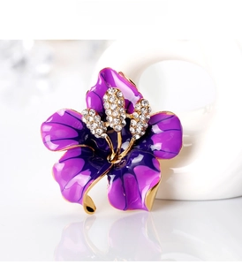 Macro detail of purple enamel flower brooch with gold plating and sparkling zircon petals
