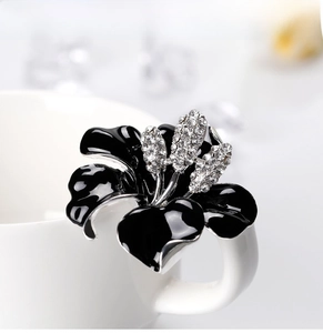Detail of elegant black enamel rose brooch with silver edges and sparkling rhinestones