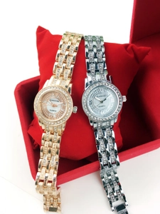 Close-up of gold and silver luxury women watches with rhinestones and shell dials.