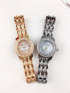 Close-up of rose gold and silver quartz watches with rhinestone bezels and Roman numerals