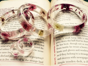 Handmade clear resin jewelry featuring real dried flowers and leaves on vintage book