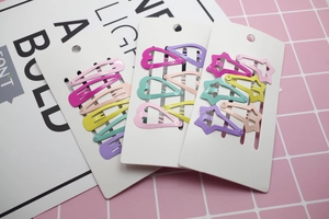 Close-up of pastel macaron-colored metal hair clips in star, heart, and drop shapes