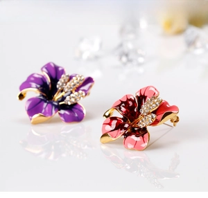 Detailed macro view of purple and red enamel rose brooches with sparkling crystals