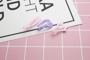 Close-up of pastel pink and purple lacquered heart and star shaped cute hair clips