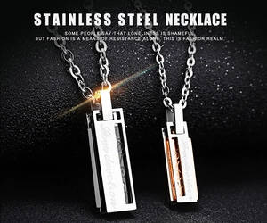 Detail of couple necklace pendants with Love devotion engraving on stainless steel bars