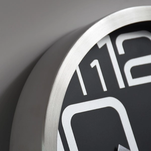 Modern silent wall clock with brushed metal frame and black dial with large white numbers