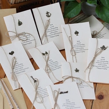 Retro cream stationery set with brown jute twine and metal charms on a wooden desk