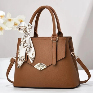 Brown lychee leather tote bag with gold buckle and decorative silk scarf accessory