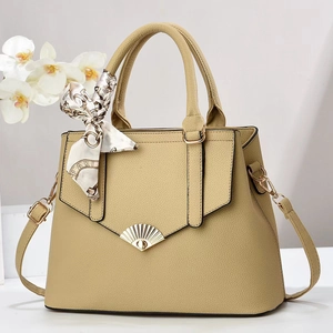 Large capacity khaki leather tote bag with silk scarf and gold hardware in studio setting
