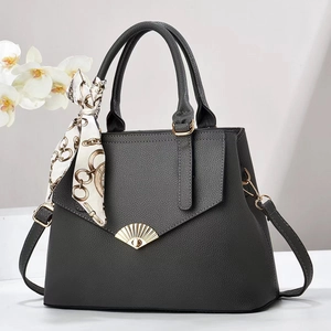 Detailed view of grey lychee leather tote with gold shell buckle and silk scarf handle