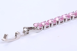 Macro shot of silver tennis bracelet with pink square zircon and fold-over clasp detail
