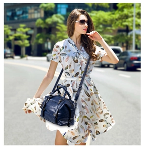 Blue crocodile pattern Boston bag styled with a white dress on a city street