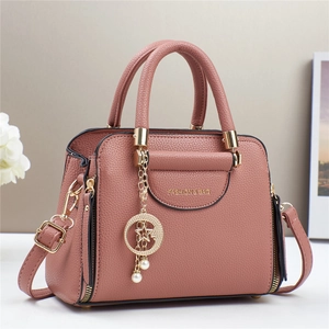 Detail of mauve faux leather bag with gold hardware, star-moon charm and brand logo