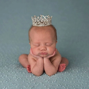 Detail of silver baby crown with rhinestones on a newborn for vintage style decoration