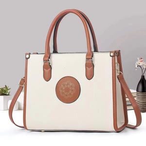 Minimalist cream tote bag with brown contrast trim and adjustable shoulder strap