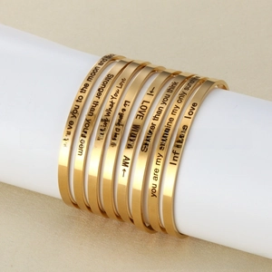 Macro shot of gold stainless steel cuffs with motivational quote engravings