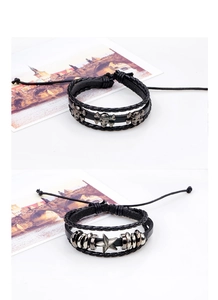 Detail of multi-layer black leather bracelets with skull and star metal charms