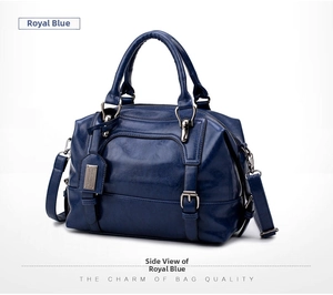 Detail view of royal blue crocodile pattern Boston bag with top handles and strap