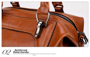 Detail showing high-quality dark metal hardware and reinforced stitching on a brown leather bag