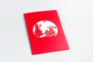 Detail of red 3D pop-up Christmas card with hollow Santa and tree cutout design