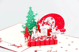Close-up of 3D Christmas card featuring paper-cut Santa, train, and reindeer details