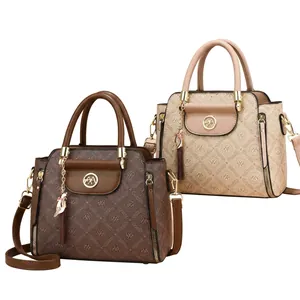 Detail view of retro monogram handbags with golden hardware and tassel in brown and beige