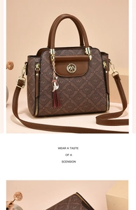 Detail of monogram leather handbag with golden hardware and cute cat tassel charm