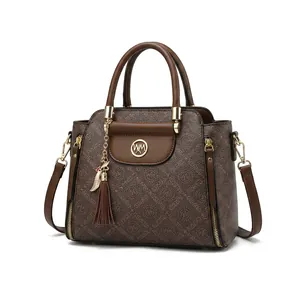 Detail view of brown cowhide leather bag with monogram texture and gold tassel hardware