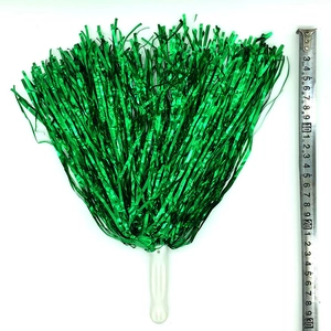 Detailed view of green pom pom with white handle and measuring tape showing size