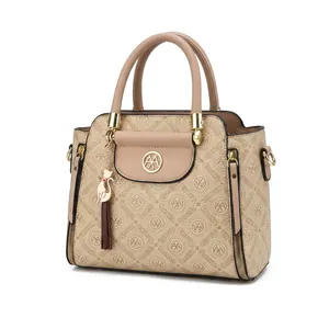 Detail of monogram leather tote bag featuring a gold ring logo and cute cat charm pendant