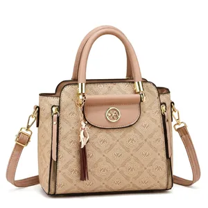 Detailed view of women's crossbody bag featuring beige monogram print and golden hardware
