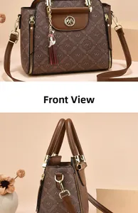 Detail view of brown monogram handbag with cat tassel and gold hardware accents
