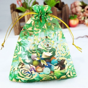 Detail of green organza gift bag with gold rose prints and metallic drawstring closure