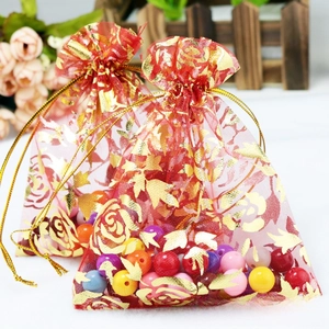 Detail of red organza gift bag featuring gold rose patterns and drawstring closure