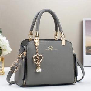 Elegant dark grey textured handbag with gold hardware and a pearl heart charm pendant
