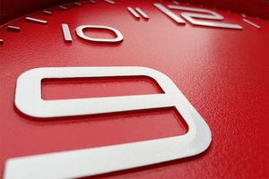 Macro detail of 3D embossed white numbers on a matte red 12-inch plastic wall clock