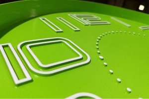 Macro detail of 3D embossed numbers on a green modern minimalist wall clock face