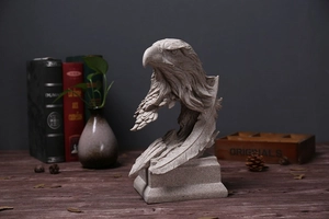 Detaillierte Adlerkopf-Skulptur im Sandstein-Stil mit Vintage-Büchern und Holzkiste