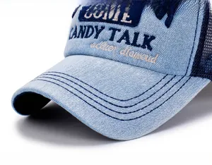 Detail of denim mesh cap featuring blue embroidery and reinforced stitching on the brim