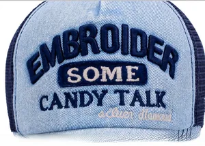 Macro detail of 3D embroidery and denim texture on a breathable mesh trucker hat