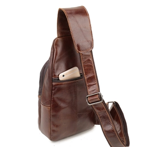Front pocket detail of brown leather chest bag showing smartphone storage capacity