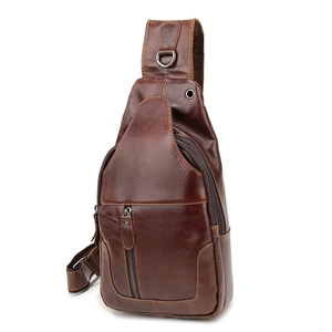 Detail of vintage brown leather chest bag showing premium texture and zipper pockets
