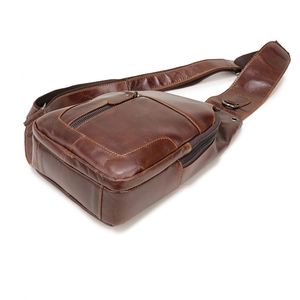 Detail view of the side and bottom structure of this dark brown leather chest bag