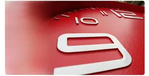 Detailed macro view of 3D embossed white numbers on a red textured silent wall clock