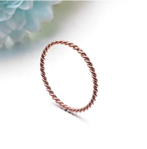 Macro shot of rose gold twisted rope ring showing detailed braided stainless steel texture